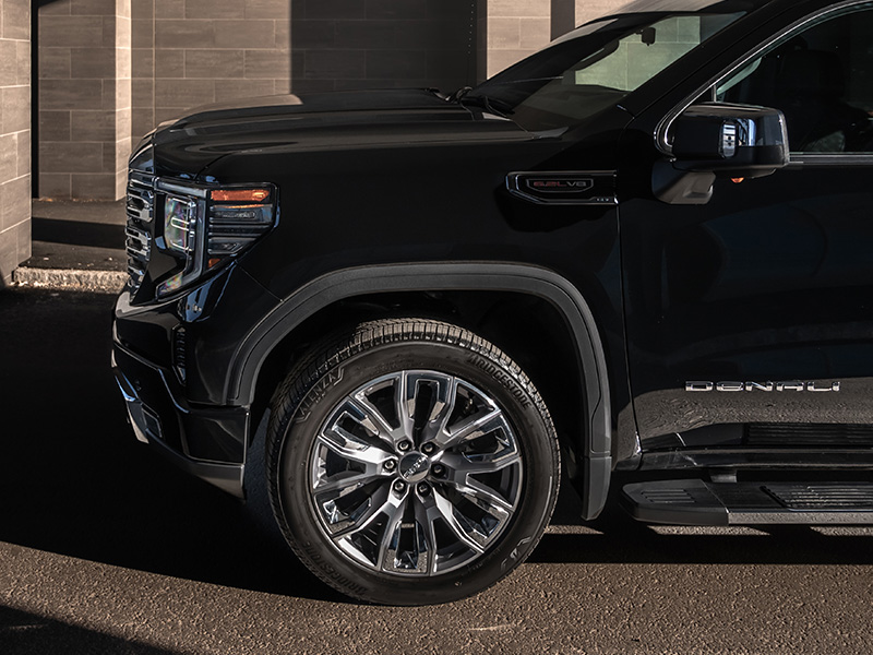 Närbild på framhjulet och framskärmen på en svart GMC Sierra Denali.