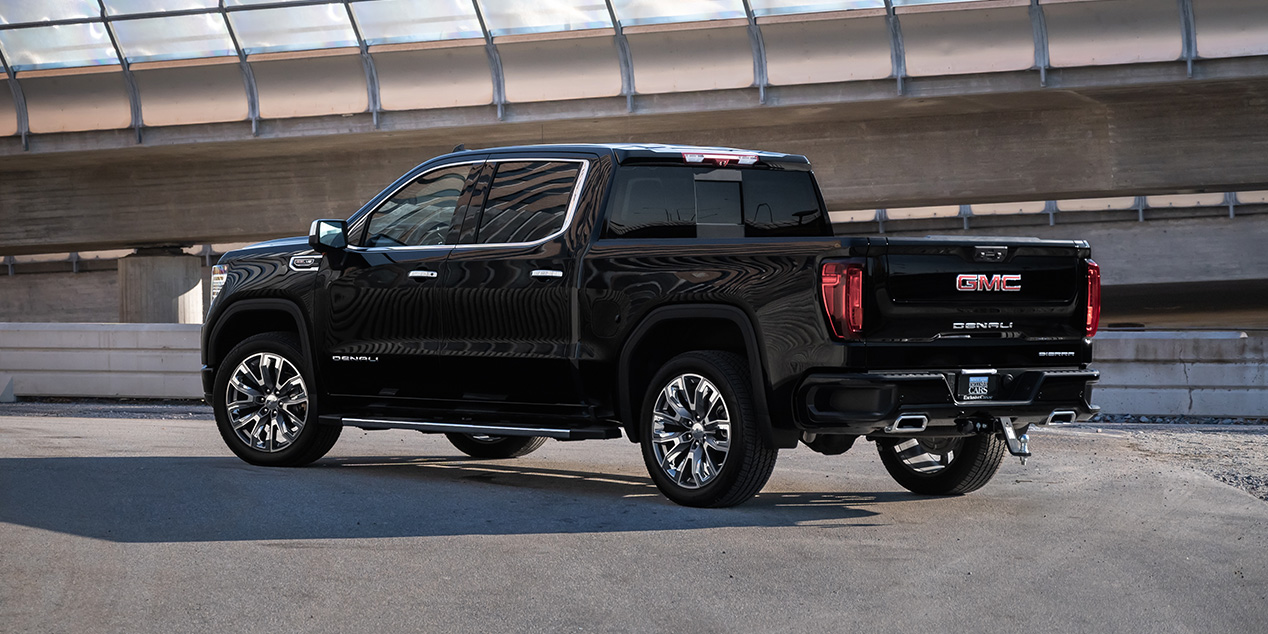 En svart GMC Sierra Denali pickup-truck parkerad på en betongyta.